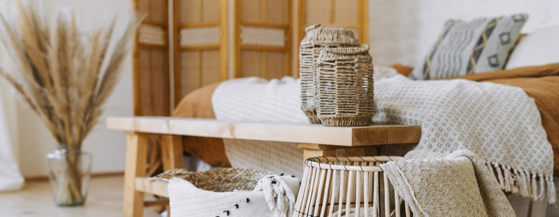 a group of baskets on a wooden table at the end of a bed